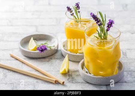 Cocktail d'été à l'orange et au citron avec lavande et romarin frais. Limonade d'été aux herbes Banque D'Images