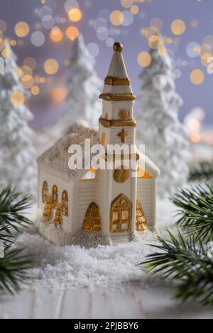 Petite église avec des bougies et des arbres blancs comme paysage enneigé. Décoration de Noël. Symbole du christianisme Banque D'Images