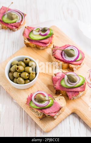 Sandwichs ouverts au rôti de bœuf avec légumes, olives et câpres Banque D'Images