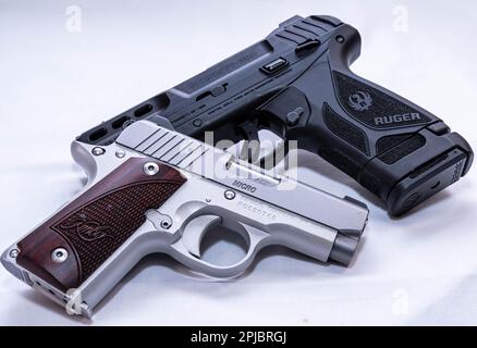 Un pistolet Kimber 380 micro 1911 en acier inoxydable avec poignées en bois et un Ruger Security 380 noir Banque D'Images