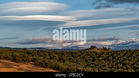 Vue panoramique de grands nuages lenticulaires sur les sommets enneigés de la Sierra Nevada (Espagne) Banque D'Images