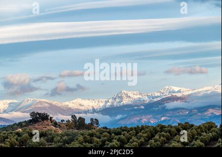 Vue panoramique de grands nuages lenticulaires sur les sommets enneigés de la Sierra Nevada (Espagne) Banque D'Images