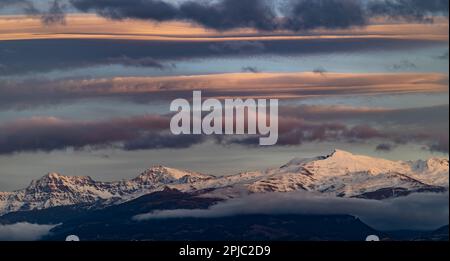 Vue panoramique de grands nuages lenticulaires sur les sommets enneigés de la Sierra Nevada (Espagne) Banque D'Images