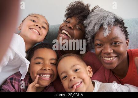 La famille africaine horizontale a pris un sourire et un selfie à la maison. Banque D'Images