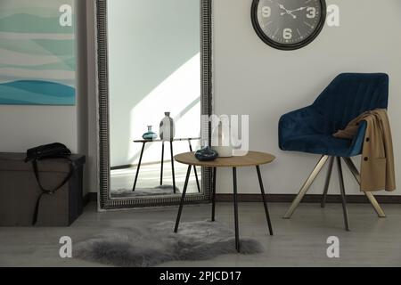 Chambre avec table en bois et fauteuil bleu. Intérieur élégant Banque D'Images