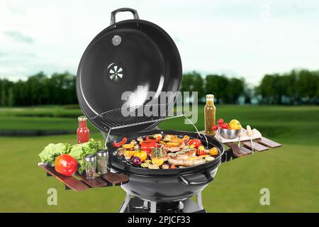 Barbecue moderne avec des plats savoureux à l'extérieur par beau temps Banque D'Images