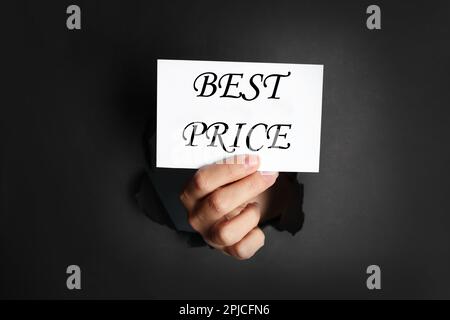 Femme tenant la carte avec l'expression meilleur trou de prix dans le papier noir, gros plan Banque D'Images