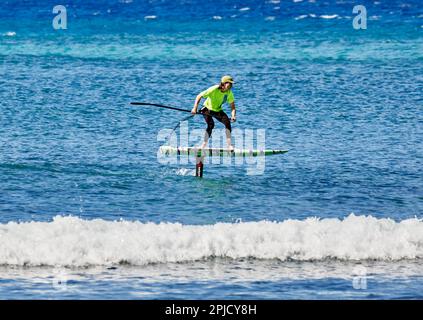 Oahu, Hawaï, Etats-Unis, - 6 février 2023: Femme adulte sur une planche de surf électrique dans l'océan Banque D'Images