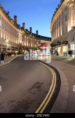 Londres, Royaume-Uni - 17 mars 2023 ; Curve of Regent Street dans le centre de Londres au crépuscule à l'approche de motion blur bus Banque D'Images