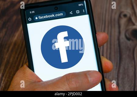 Lac Elsinore, Californie, États-Unis - 1 avril 2023 : homme utilisant l'application Facebook sur smartphone Banque D'Images