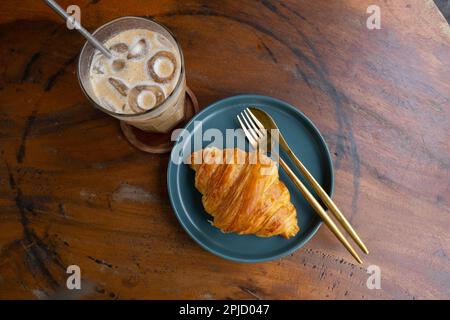 Un petit déjeuner simple, un verre de glace. faites un café avec un croissant au beurre pour commencer la journée Banque D'Images