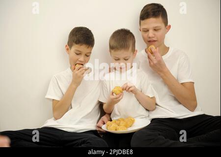 Trois jeunes garçons regardent un film à la télévision. Photo de haute qualité Banque D'Images