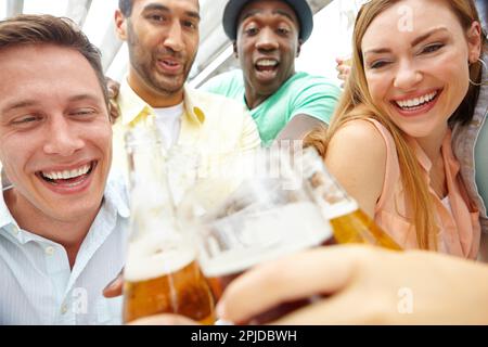 Clink. Un groupe de jeunes amis se rassemblent dans un restaurant pour prendre un verre. Banque D'Images