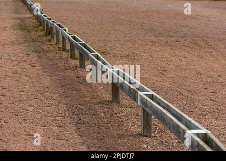 Barrières en bois basses séparant les places de stationnement sur un parking. Banque D'Images