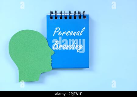 Concept de marque personnelle. Profil de la tête humaine à côté du bloc-notes bleu avec texte écrit. Banque D'Images