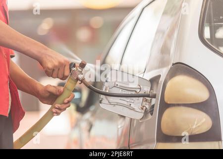 Karachi pakistan 2021, buse de gaz GNC remplissant le gaz dans une voiture, prix du carburant, stations-service au pakistan, faible profondeur de champ Banque D'Images