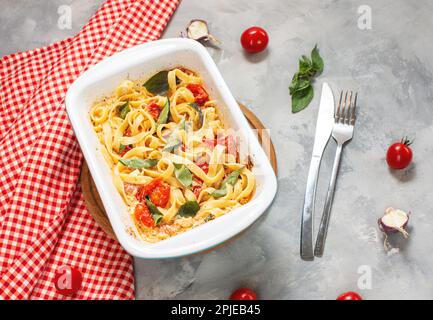 Fetapasta. Recette de pâtes à la mode de la Fêta virale faite de tomates cerises, de feta, d'ail et d'herbes dans un plat de cocotte. Banque D'Images