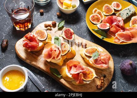 Hors-d'œuvre avec tapas espagnols traditionnels. Antipasti italiens bruschetta au prosciutto, fromage à la crème et figues Banque D'Images