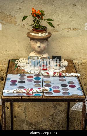 Tables d'un petit restaurant le long des rues étroites de la vieille ville de Syracuse, Ortigia. Les céramiques décorent et embellissent la table. Sicile Banque D'Images