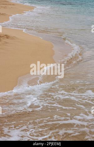 Sable doré à la plage, avec une touche douce d'une vague calme de l'océan Atlantique. Parque Natural Dunas de Corralejo, Fuerteventura, Espagne. Banque D'Images