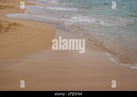 Sable doré à la plage, avec une touche douce d'une vague calme de l'océan Atlantique. Parque Natural Dunas de Corralejo, Fuerteventura, Espagne. Banque D'Images