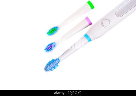 Vue rapprochée d'une brosse à dents électrique blanche avec trois têtes de brosse isolées sur fond blanc. Banque D'Images