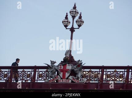 Londres, Royaume-Uni. 8 février 2023. Un piéton traverse le pont routier orné du viaduc Holborn, qui enjambe la vallée de Farringdon Street. La scène présente un lampadaire central à trois têtes décoré des armoiries de la City of London. La devise latine inscrite sur les armes, 'domine Dirige nos', se traduit par 'Seigneur, guide-nous' (ou 'Seigneur, dirige-nous'). Cette merveille d'ingénierie victorienne, conçue par William Haywood et ouverte par la reine Victoria en 1869, est célèbre pour ses statues en bronze, ses lions ailés et ses parapets en fonte qui symbolisent la richesse et le progrès du Square Mile Banque D'Images