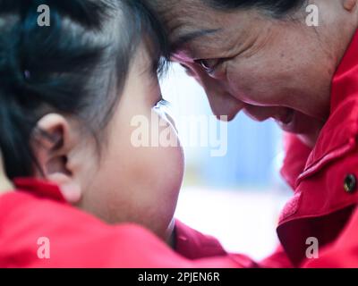 (230402) -- XINING, 2 avril 2023 (Xinhua) -- Chen Zhifang (R) présente une formation d'expression pour un enfant autiste au Centre de services spéciaux pour enfants Starlight à Xining, dans la province de Qinghai, dans le nord-ouest de la Chine, à 30 mars 2023. Chen Zhifang est le fondateur du Starlight Special Children Service Centre à Xining. Fondé en 2015, le centre de services est un organisme sans but lucratif de protection sociale publique qui offre une formation et une intervention en réadaptation précoce aux enfants atteints d'autisme, de déficience intellectuelle et de troubles du langage. Actuellement, 132 enfants autistes reçoivent divers tr de réadaptation Banque D'Images