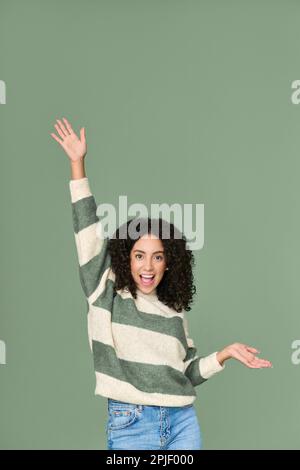 Jeune femme latine heureuse et excitée ayant une danse amusante isolée sur le vert. Banque D'Images