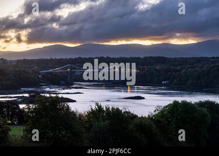 Pont Menai, Anglesey, au nord du pays de Galles, au crépuscule à la mi-octobre. Un célèbre pont suspendu au-dessus du détroit de Menai. Banque D'Images