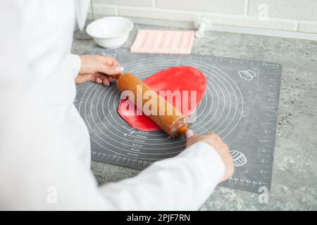 Le chef pâtissier fait du mastic pour décorer le gâteau. Pâte élastique, pâtisseries délicieuses, processus de cuisson. Production à domicile, passe-temps, esprit d'entreprise. Banque D'Images