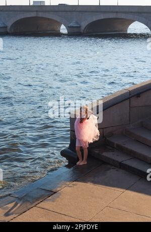 Belle petite fille joue avec les vagues au coucher du soleil. Été Sunny Day, Happy Kids concept Banque D'Images