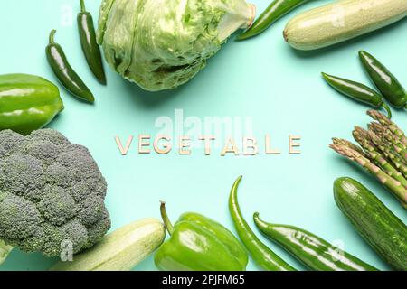 Mot LÉGUME et cadre fait de différents légumes frais sur fond bleu Banque D'Images