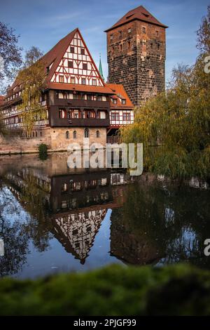 Réflexion verticale d'eau de Weinstadel en Allemagne. Ancien bâtiment avec tour d'eau et rivière Pegnitz à l'automne Nuremberg. Banque D'Images