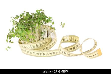 Moutarde microverts, super nourriture. Un bouquet de verts de moutarde est enveloppé dans un ruban de centimètre jaune. Les Microgreens favorisent la perte de poids, le régime, l'équilibre des noix Banque D'Images