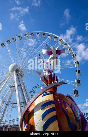 Le mémorial John Lennon se dresse contre la grande roue de Liverpool Banque D'Images