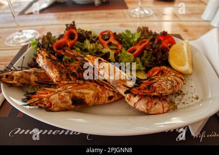 Une assiette de crevettes grillées au charbon de bois dans un petit restaurant local à Santorini, Grèce Banque D'Images