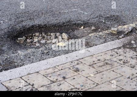 Pothole sur Winchester Road est en bas de la base secondaire, Basingstoke, Royaume-Uni. Le manque de financement pour l'entretien local des routes est le plus élevé depuis des années. Mars 2023 Banque D'Images