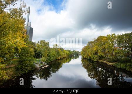 Hanovre, Allemagne - 14 octobre 2022. Belle rivière Ihme avec arbres et en arrière-plan la centrale de chauffage avec les trois tours Banque D'Images