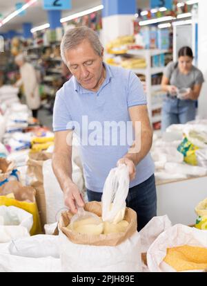 Homme âgé qui achète de la farine de maïs à l'épicerie Banque D'Images