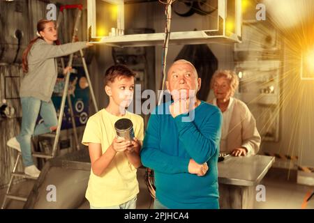 Petits-enfants et grands-parents dans la salle d'évacuation Banque D'Images