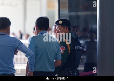 Phnom Penh, Cambodge - 01 septembre 2018: Policier dans la veste à l'épreuve des balles parlant deux employés de l'aéroport international de Phnom Penh à côté de la principale Banque D'Images