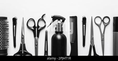 Ensemble avec ciseaux et autres accessoires de coiffeur sur fond blanc, plat. Bannière Banque D'Images