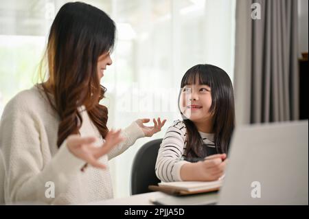 Une adorable jeune fille asiatique aime parler avec sa mère tout en faisant des activités amusantes à la maison ensemble. Banque D'Images