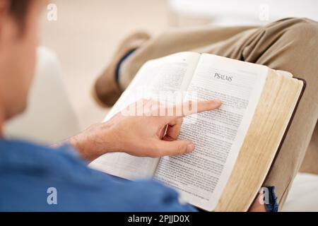 Plonger dans le mot. Un homme lisant la Bible à la maison. Banque D'Images