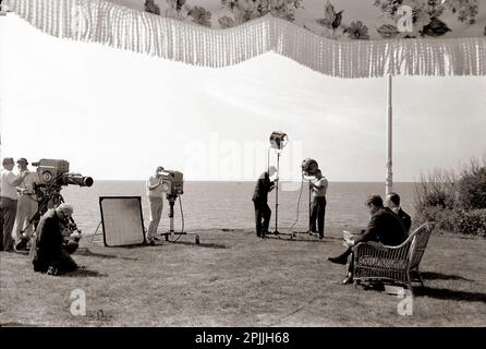 ST-C276-2-63 2 septembre 1963 entretien de Walter Cronkite avec le Président John F. Kennedy. Le président Kennedy et Walter Cronkite s'assoient à l'extérieur pendant qu'une équipe de télévision CBS filme l'entrevue. La photographie inclut le président Kennedy, Walter Cronkite, l'équipe de télévision et les techniciens. Vue sur l'océan en arrière-plan. Squaw Island, Port de Hyannis, Massachusetts. Veuillez indiquer « Cecil Stoughton ». Photos de la Maison Blanche. John F. Kennedy Presidential Library and Museum, Boston Banque D'Images