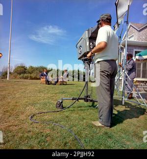 ST-C276-9-63 2 septembre 1963 le président John F. Kennedy est interviewé par Walter Cronkite. Le président Kennedy et Walter Cronkite sont assis à l'extérieur dans des chaises en osier, tandis que l'équipe de télévision de la SCS filme l'entrevue. Squaw Island, Port de Hyannis, Massachusetts. Veuillez indiquer « Cecil Stoughton ». Photos de la Maison Blanche. John F. Kennedy Presidential Library and Museum, Boston Banque D'Images