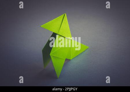 L'origami en papier vert est isolé sur un fond gris vierge. Cocotte en papier Banque D'Images