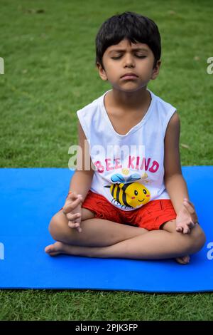 Asiatique chic enfant faisant le yoga pose dans le parc de la société en plein air, pose de yoga pour enfants. Le petit garçon faisant de l'exercice de yoga Banque D'Images