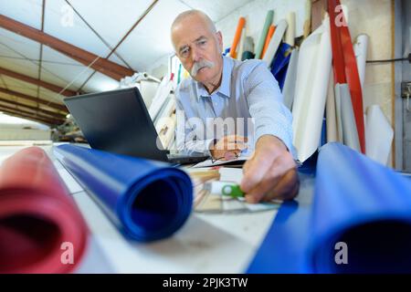 homme senior avec ordinateur portable et disque dur externe Banque D'Images